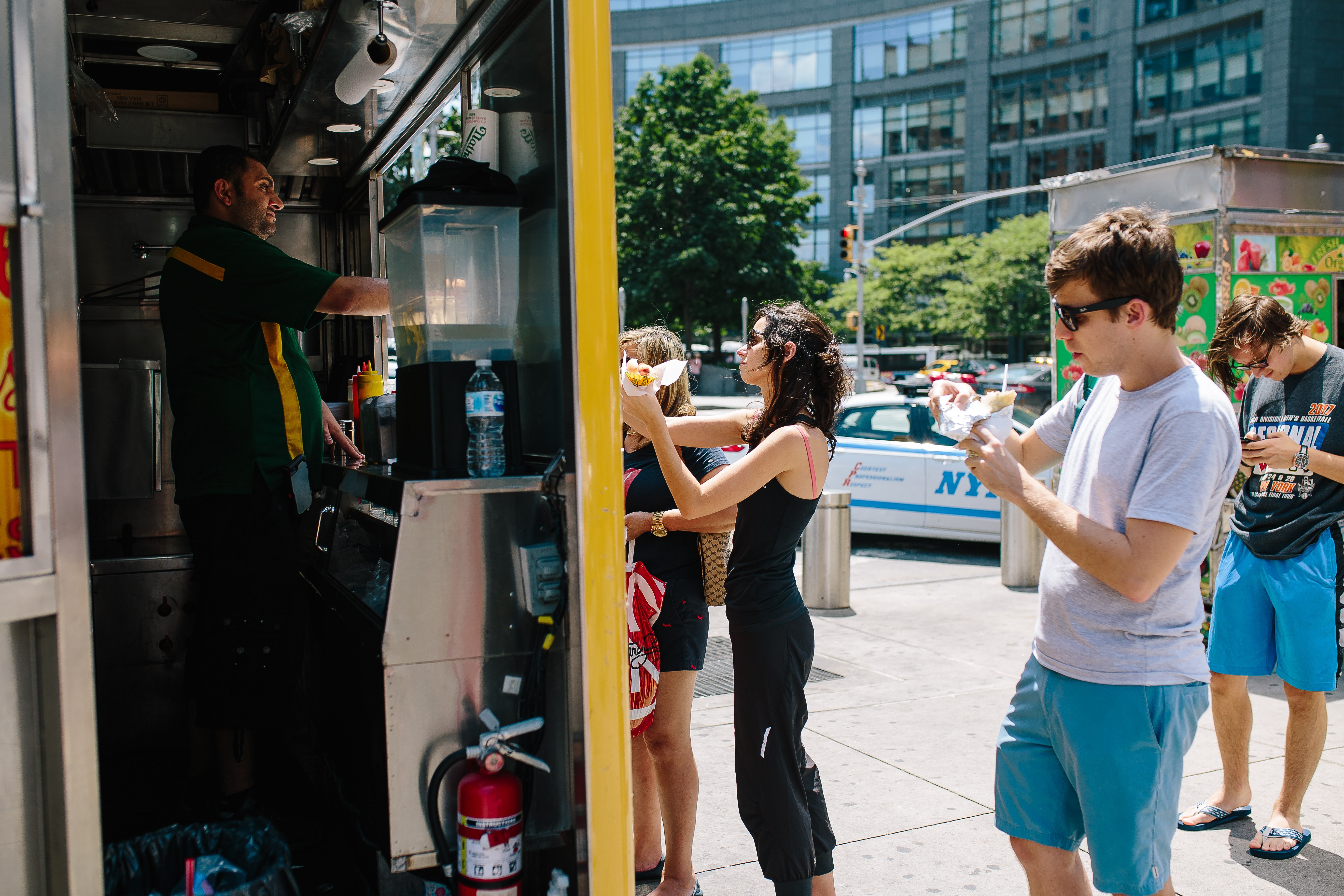 photo of people eating at hot dog cart NYC